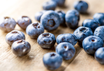 Freshly blueberries on wooden rustic wooden table. Juicy and fresh blueberries with green leaves. Bilberry on wooden background. Blueberry antioxidant. Concept for healthy eating and nutrition.