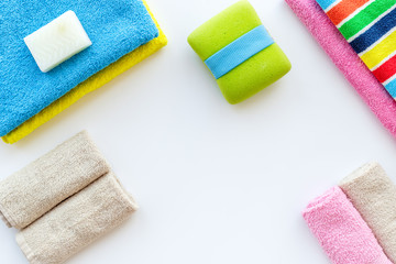 Preparing to take bath. Towels and soap on white background top view copyspace