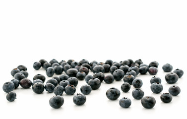 Ripe blueberries scattered on a white background