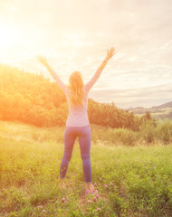 Woman enjoying in the nature with arms wide open.