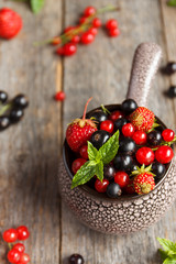 Fresh berries. Various summer berries in a bowl on rustic wooden table.