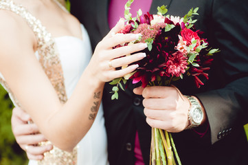 Groom hugs bride with wedding bouquet