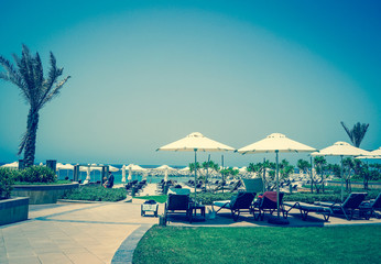 Dubai. Oasis of Paradise. The beach with sunbeds and sunshades in Dubai, on the shores of the Arabian Gulf. Toning.
