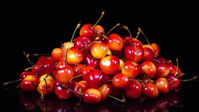 Excellent side of red and yellow fresh sweet cherries with stems in heap, rotating to the right. Yummy berries with amazing texture in 4k, 3840x2160, clip. Vibrant eco product for healthy food.
