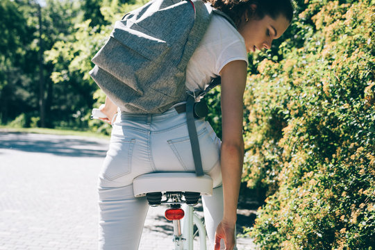 Young slender woman on a bicycle with a backpack