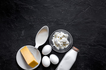 Obraz na płótnie Canvas Natural food. Milk, cottage, cheese, eggs on black stone background top view copyspace