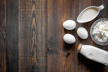 Farm products. Milk, cottage, eggs on dark wooden background top view copyspace