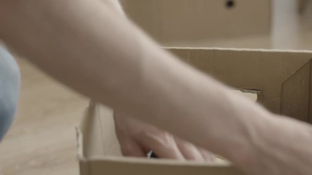 Man pulls a hammer out of the box. Man doing home renovations and pulls a hammer out of the box