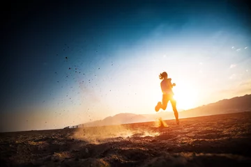 Fotobehang Woman runs on the desert with lots of dust © Dudarev Mikhail