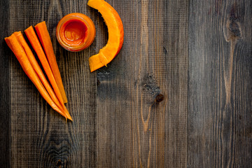 Baby food. Pumpkin puree on dark wooden table background top view copyspace