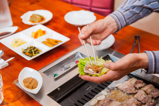 Korea traditional way of eating grilled dish in Korean cuisine. Meat is served raw, then cooked on tabletop grill. Close up. selective focus.