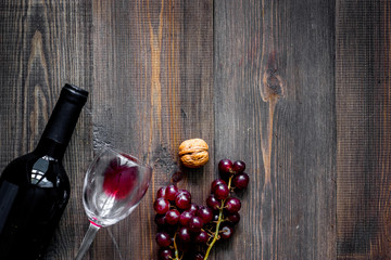 Serve wine. Bottle, glass, nuts and grape on wooden table background top view copyspace