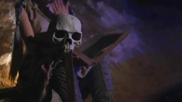 Human skull in focus and girl with book in defocus