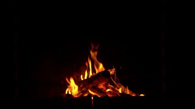 Fire burning in the fireplace - slow motion - dark background