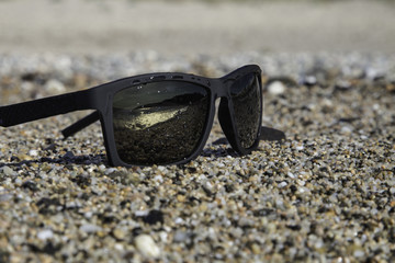sunglasses on pebble background