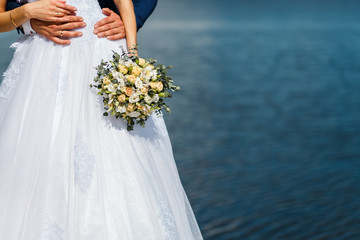 wedding bouquet with yellow roses and eucalyptus in bride's hands