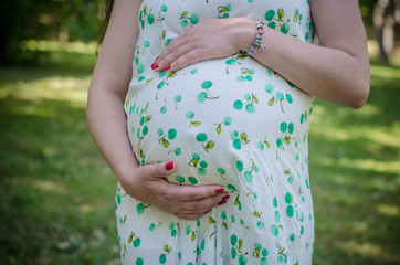 Close up of pregnant belly in summer dress