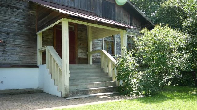 Porch of an old wooden house with stone steps