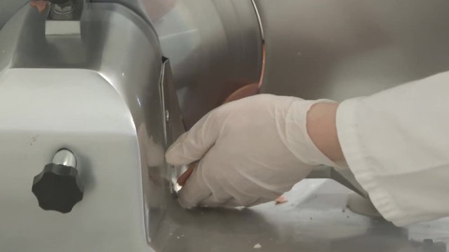butcher cut salami on a machine