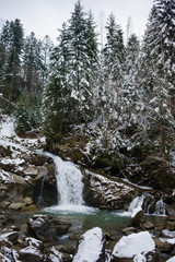 Fototapeta na wymiar Winter forest river with many waterfalls