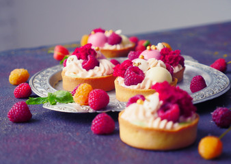 Cakes with strawberries and berries. Raspberry Cakes on dark background. Tasty Raspberry Tarts on a Vintage Plate. Wonderful Sweet Desserts. Mini tarts with Raspberries. Raspberry fruit tart.