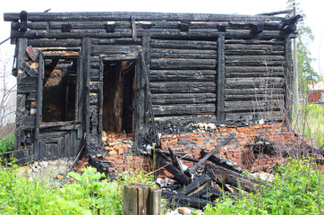 Burned down wooden house, charred walls, burnt roof, black ceilings