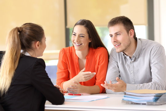 Happy customers talking with office worker