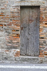 Ancient wooden door on a brick wall