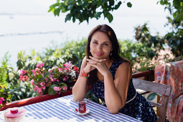 Fototapeta premium Young woman in cafe with glass of tea on the table