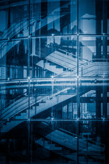 Empty staircase in an office building seen through glass wall,blue tone.