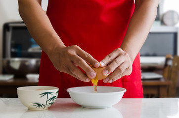 Hand cracking egg into a bowl for cooking,food ingredient