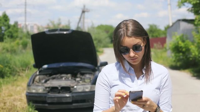 woman and broken car calling for help on cell phone. broken car on the road offroad village, crash concept