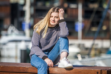 outdoor portrait of young happy smiling teen girl on marine background on a sunny day, auckland...