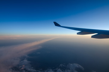Fototapeta na wymiar Airplane wing and blue sky