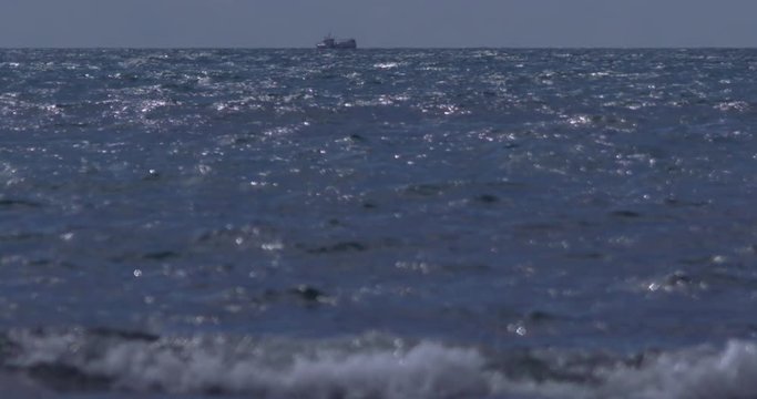 Small boat on horizon. Waves breaking. Slow motion 180fps