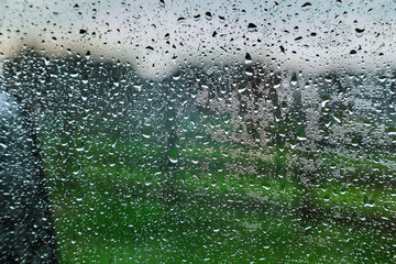 After rain water beads drizzling glass window of the resort.