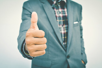 Close up of hand businessman thumbs up  on blue background