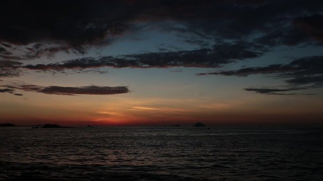 Sunrise sky fishing boats and a tropical island at dawn looking out over the south China sea in Vietnam. High definition time lapse stock footage.
