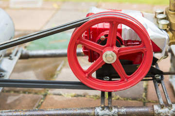 Old and rusty water pump motor with red pulley wheel and belt, Dirty water pump and belt