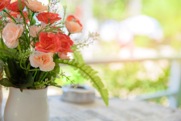 vase of plastic flowers decoration on table with natural light