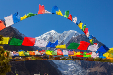 Colorful prayer flags, blowing in the wind in the Himalaya, on the Annapurna trekking circuit in...