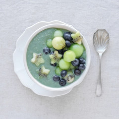 Blue spirulina smoothie bowl with melon, kiwi fruit and blueberries