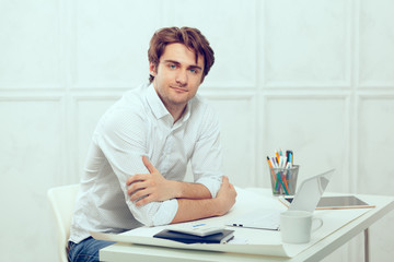 Businessman using laptop with tablet and pen