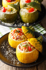 Fototapeta na wymiar Baked zucchini stuffed with bulgur, meat, cheese and vegetables close-up. vertical