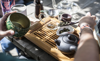 Traditional Chinese tea ceremony - a hand holding a wooden spoon with Chinese green tea