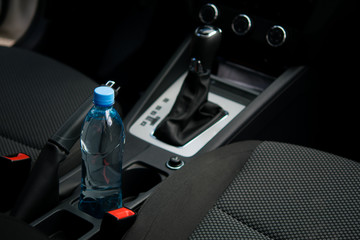 In a car in a cup holder there is a bottle of water