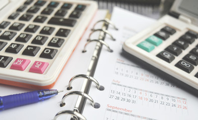 Business Concept on Diary with 2 calculators and pen