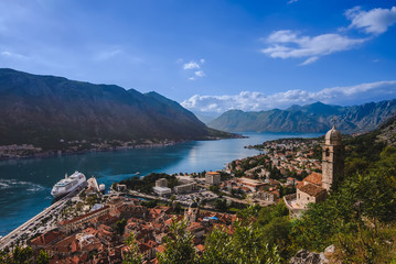 Kotor Bay and Old Town view from above Kotor's castle of San Giovanni. Stone staircase, traditional house roofs, cathedral dome and Boka Kotorska wide angle view.