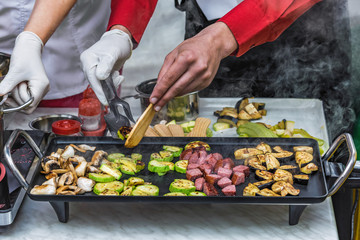 cooking sausages, vegetables, mushrooms on the grill