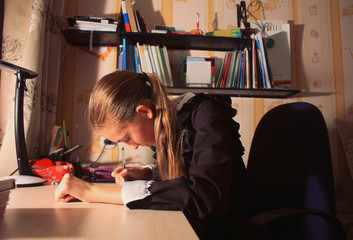 school girl writing something in an exercise book, doing homework